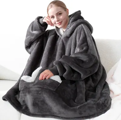 Showcases the comfort and warmth of the wearable blanket product Demonstrates the product's use in a comfortable, casual environment
