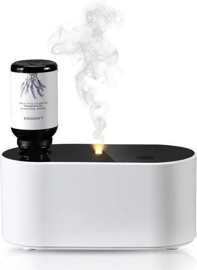Shows the product actively diffusing lavender essential oil with visible vapor, demonstrating how it works in a real-world setting to help shoppers visualize the aromatherapy experience.