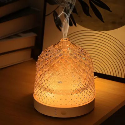 Demonstrates the product in a real-world home setting to showcase its warm ambient lighting and mist diffusion functionality, helping shoppers visualize how it enhances their living space.