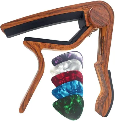 Shows the guitar capo along with all included colorful guitar picks to communicate the full value of the purchase and what the buyer will receive.