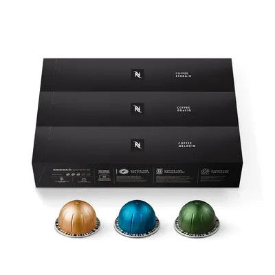 Showcases the product in its elegant retail packaging alongside the coffee capsules to communicate brand quality and professionalism. Displays three different coffee capsule varieties to show…