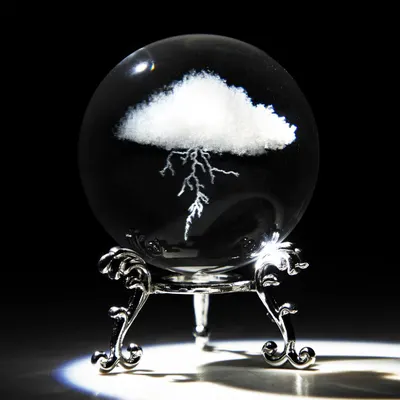 Showcases the core product, a decorative crystal sphere with an embedded cloud and lightning design, displayed on an ornate stand to communicate its artistic and collectible nature. Uses a black…