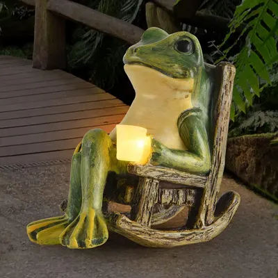Shows the decorative frog statue in a real outdoor garden setting to help shoppers visualize how it will look in their own yard or patio space. Demonstrates the product's lighting function by…