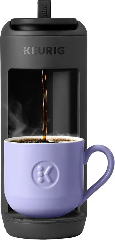 Shows the coffee maker actively brewing coffee into a mug, demonstrating how the product works and what it does in real use. Displays the core sellable Keurig coffee maker product clearly with a mug…