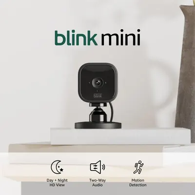 Shows the Blink Mini security camera in a lifestyle setting to help shoppers visualize its size and placement in their home. Demonstrates the camera in a real home environment on a shelf to show how…