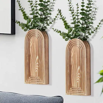 Shows the wooden arch vases styled in a real home environment with greenery to help shoppers visualize how the product will look in their own living space. Displays the core sellable product - a set…