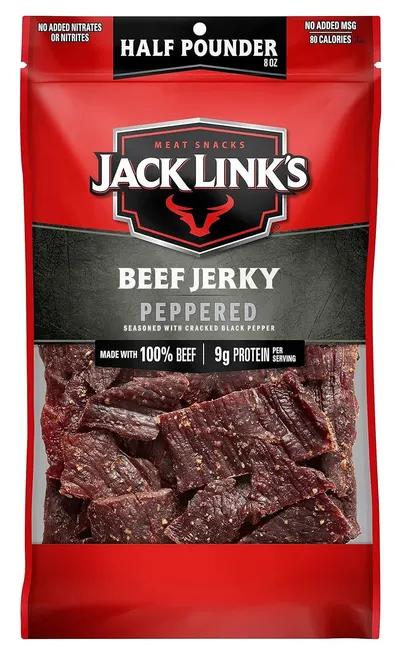 Displays the Jack Link's beef jerky product in its retail packaging with a clear window showing the actual jerky pieces, communicating the flavor variant, protein content, and quality ingredients to…