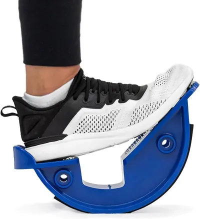 Shows a person using the product to demonstrate its size, how it fits under the foot, and how it is used for stretching or balance exercises. Demonstrates the product actively in use as a foot…