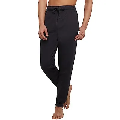 Shows the core product, black drawstring pants, worn by a model to demonstrate fit and style for shoppers. Uses a human model to help shoppers visualize how the pants fit on the body and understand…