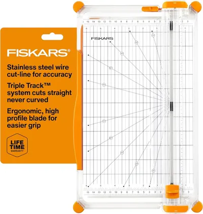 Shows the core Fiskars paper trimmer product clearly with its measurement grid, cutting guides, and orange safety corners, allowing shoppers to see exactly…