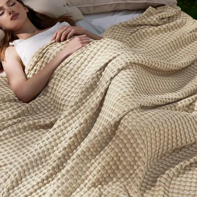 Shows the product in a real-world bedroom setting with a model using it, helping shoppers visualize how the blanket looks and feels in their own home for comfort and relaxation. Features a person…