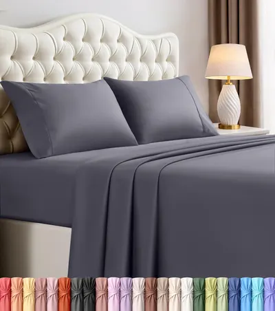 Displays the core product, a bed sheet set in gray, styled on a bed to show how it looks when in use and to communicate quality and fit. Shows the wide range…