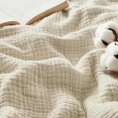 Shows the product in a cozy, real-world lifestyle setting with natural cotton elements to communicate comfort, quality, and organic appeal to shoppers. Uses decorative cotton bolls as visual props…