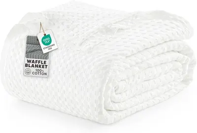 Displays the core product, a white waffle-textured cotton blanket, in a clean catalog style to show its texture and quality. Shows the retail hang tag that communicates key product details like…