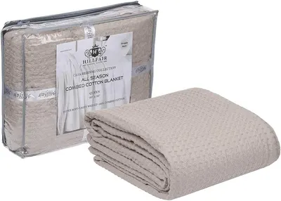 Displays the core product, a folded combed cotton blanket, to show the shopper what they will receive. Shows the retail packaging alongside the product to communicate how the blanket is delivered…