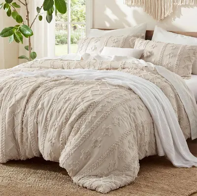 Showcases the complete bedding set with its distinctive textured tufted pattern in a neutral color palette, helping shoppers visualize the product's aesthetic and quality. Displays the bedding in a…