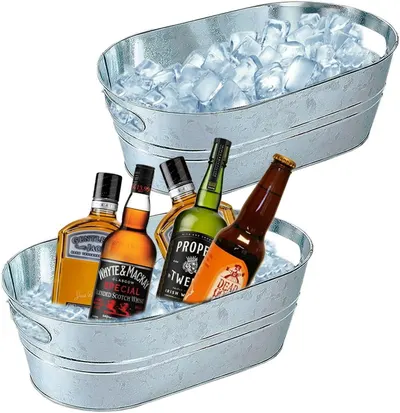 Shows the galvanized metal oval tubs as the core product, including a two-tub set, so shoppers see the size and style. Places the tubs in a party-style drinks setting with ice and bottles to suggest…