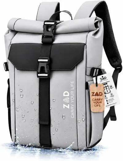 Shows the core backpack clearly so shoppers can see its roll-top shape, buckle straps, and grey finish. Water droplets and splash effects reinforce the water-resistant claim and give the product…