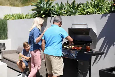 Shows the product being used in a real-world backyard setting by a family, highlighting its suitability for outdoor cooking and gatherings.
