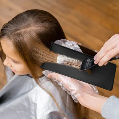Demonstrates the proper way to apply hair color or dye using the product brush.