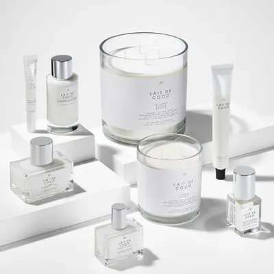 Shows the various products included in the Lait de Coco line, such as candles, lotions, and fragrances, to highlight the full range of offerings.