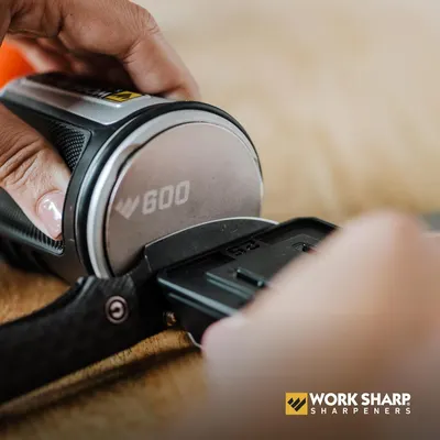 Demonstrates how to use the Work Sharp knife sharpener, showing the proper technique for sharpening a blade.