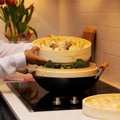 Demonstrates how to use the product for steaming multiple types of food simultaneously, showcasing its versatility and ease of use in cooking.