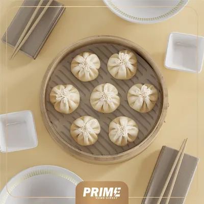 Shows the product (steamer basket with dumplings) in a real-world dining context to help shoppers visualize how it would be used in their own homes.