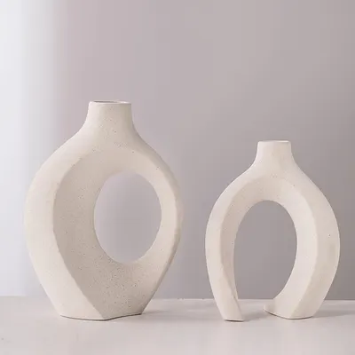 Showcases the vases in a clean, minimalist setting to highlight their unique shape and aesthetic appeal as decorative objects.