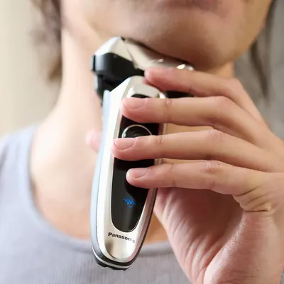 Demonstrates the correct way to hold and use the Panasonic electric shaver, helping customers understand how to operate the product effectively.