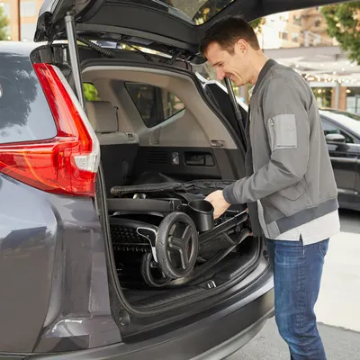 Demonstrates how the product (likely a stroller or baby gear) can be easily folded and stored in a car trunk, highlighting its portability and convenience for travel.