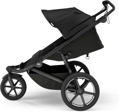 Shows the stroller in a realistic outdoor setting to demonstrate its suitability for everyday use and outdoor activities.