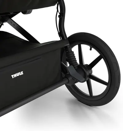 Highlights the stroller's rear wheel suspension system, demonstrating its ability to provide a smooth ride.