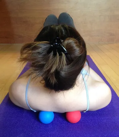 Demonstrates how to use massage balls for back pain relief or muscle tension release.