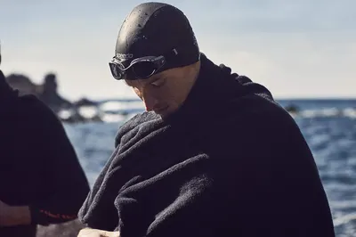 Shows the product being used in a real-world open water swimming context, emphasizing its suitability for outdoor aquatic activities.