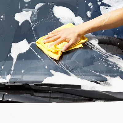 Demonstrates the proper technique for cleaning a car windshield, showing the product in use.