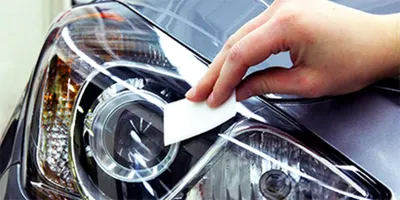 Demonstrates how to clean or polish a car headlight, showing the ease of use and potential for improving vehicle appearance.