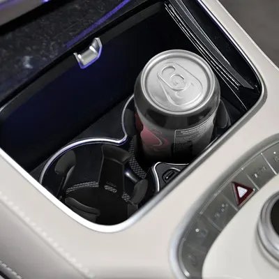 Showcases the vehicle's cup holder design, emphasizing its ability to securely hold different sizes of beverage containers.