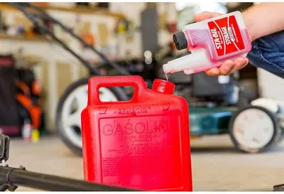 Demonstrates how to add fuel stabilizer to a gasoline container, educating users on proper storage and maintenance of fuel.