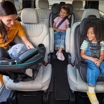 Demonstrates the vehicle's spacious interior and ability to accommodate multiple child car seats, appealing to families with young children.