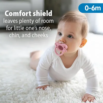 Highlights the pacifier's comfort shield feature that provides space for the baby's nose, chin, and cheeks, ensuring a comfortable fit.