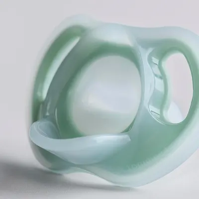 Highlights the product's unique ergonomic shape, suggesting comfort and ease of use for the consumer.