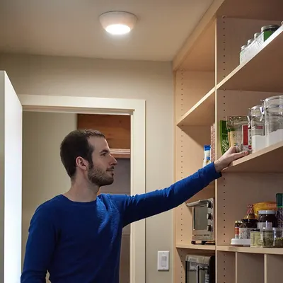 Shows the product in use within a real-world context, demonstrating how it provides illumination in a pantry or storage area.