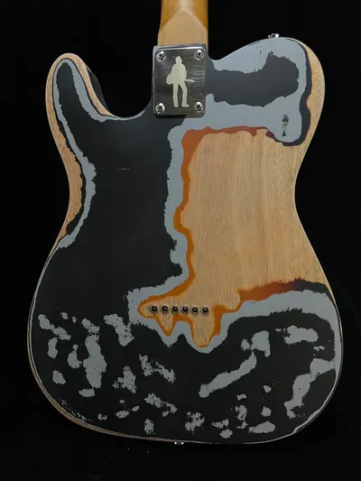Showcases the guitar's distinctive worn finish and custom neck plate, emphasizing its one-of-a-kind aesthetic appeal.
