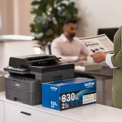 Shows the printer in use in a real office setting to demonstrate its suitability for professional environments. Highlights that the product comes with toner cartridges, emphasizing the complete…