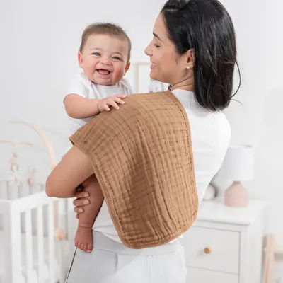 Shows the product in use, highlighting the comfort and happiness of both mother and baby to appeal to new parents.