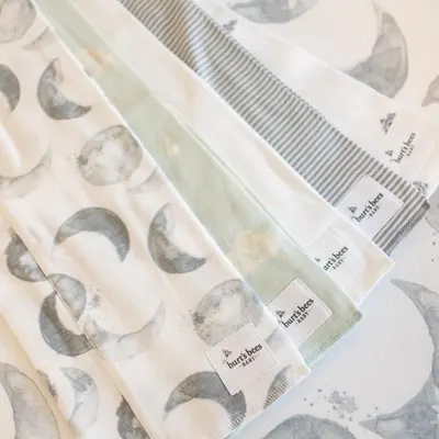 Showcases the variety of fabric patterns included in the product set, likely burp cloths or baby blankets.