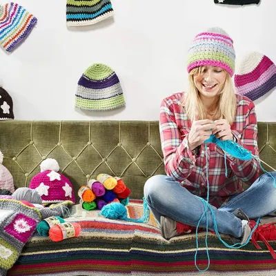 Showcases the versatility of crochet yarn and patterns by displaying multiple finished projects and works-in-progress. Depicts a relaxed, enjoyable crafting scene to appeal to hobbyists and convey…