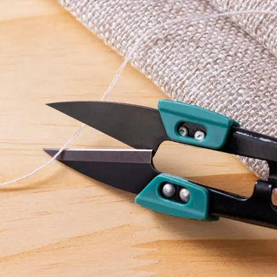 Demonstrates the product's ability to cleanly cut through thin threads, highlighting its sharpness and precision for detailed work.