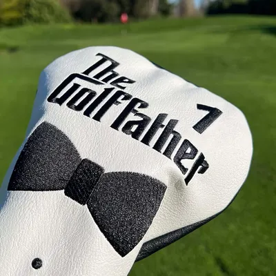Demonstrates the product in its intended environment on a golf course, showcasing its design and branding Highlights the unique branding of the golf club cover with 'The Godfather' text and bow tie…